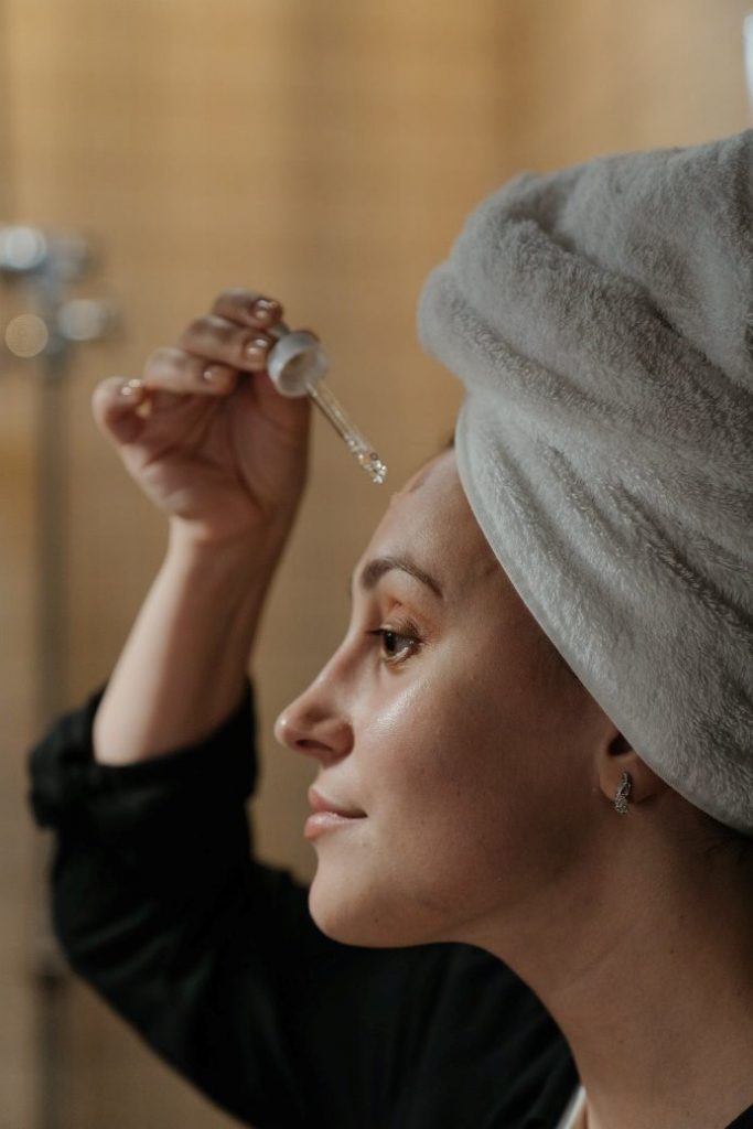 A woman applying a serum for skincare purposes