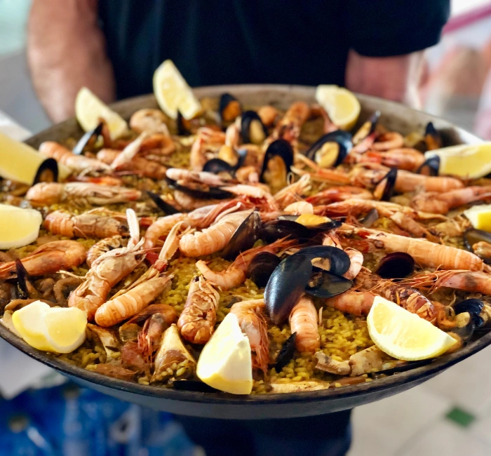 Delicious traditional Spanish paella with seafood, garnished with lemon wedges - a culinary highlight in Granada, Spain.