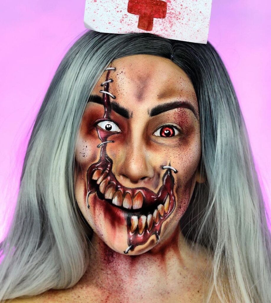 Person wearing twisted nurse-themed Halloween makeup with a gory, sharp-toothed smile, red and white contacts, and a blood-splattered nurse's cap.