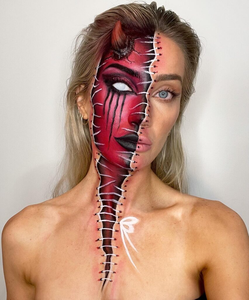 Person wearing half-demon Halloween makeup with red skin, black detailing, a horn, stitched seams, and dripping black tears on one side, contrasted with a natural face on the other.