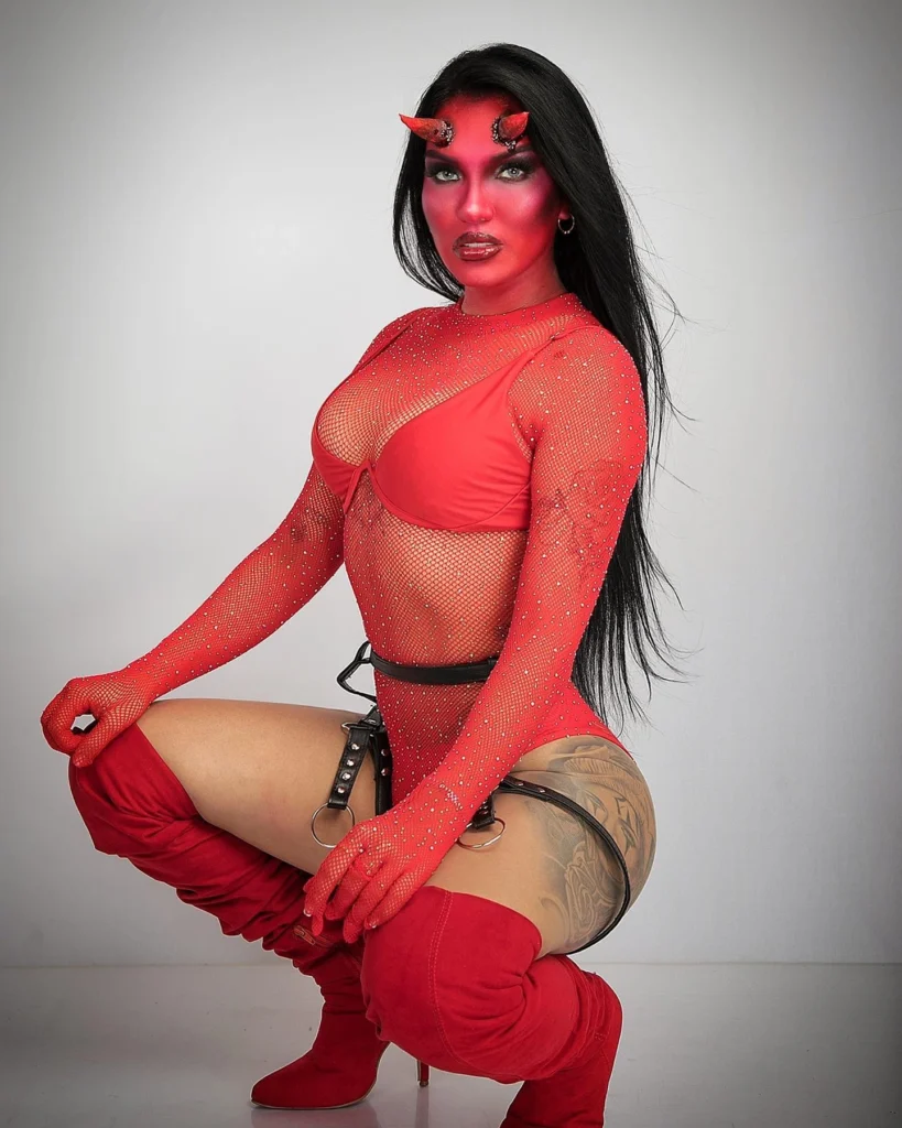 Devil costume featuring red body paint, fishnet bodysuit, and thigh-high boots.