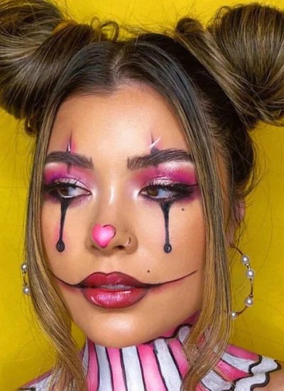 Creative Halloween makeup ideas featuring a pastel clown-inspired look with bold pink eyeshadow, black teardrop accents, and a heart-shaped nose for a playful and striking Halloween appearance.