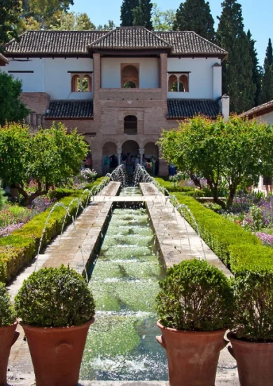 The beautiful Generalife Gardens in Granada, Spain, showcasing a serene fountain, lush greenery, and traditional Moorish architecture. A must-visit spot on your list of things to do in Granada Spain.