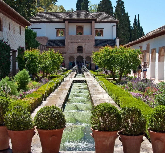 The beautiful Generalife Gardens in Granada, Spain, showcasing a serene fountain, lush greenery, and traditional Moorish architecture. A must-visit spot on your list of things to do in Granada Spain.