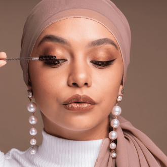 Muslim woman applying mascara